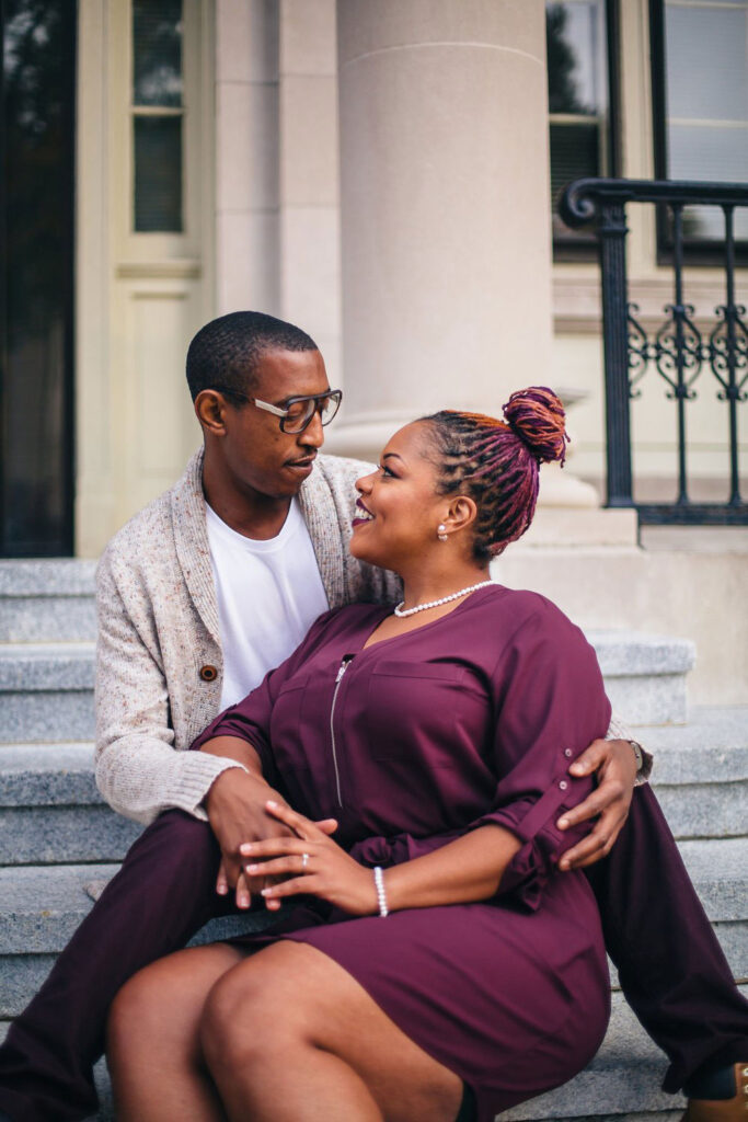 Close-up of Adriane and Caldwell sitting on stairs and looking at each other