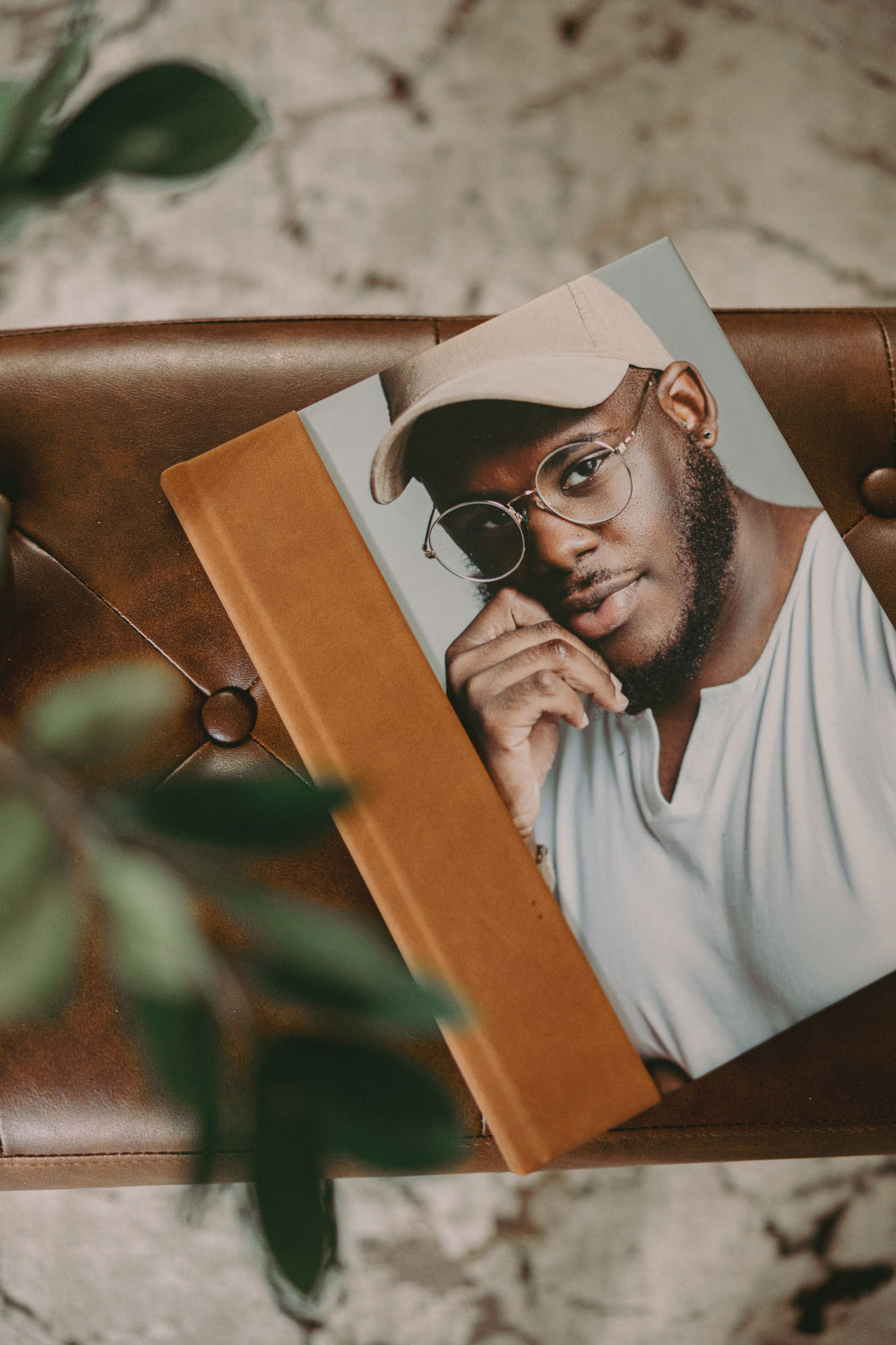 luxury leather photo album on coffee table beside houseplant