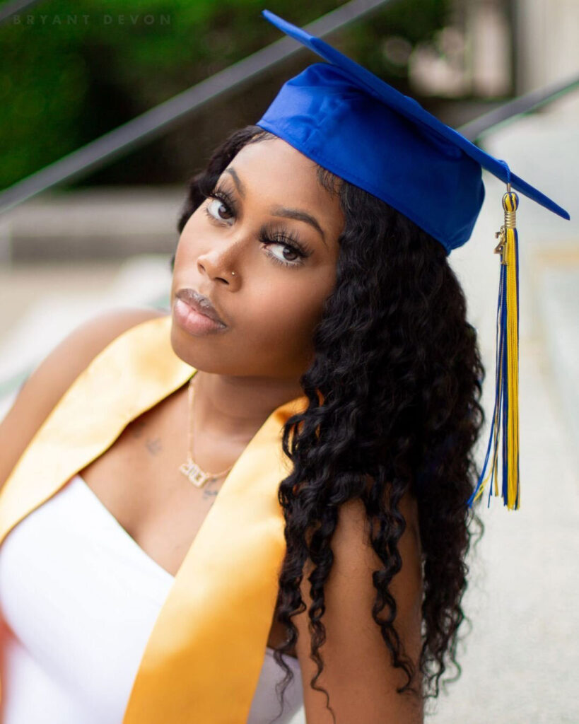 black girl in white dress in a stunning cap and gown headshot