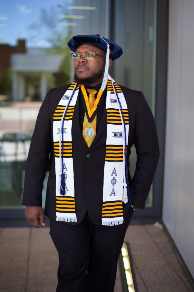 doctoral student in tam and alpha phi alpha stoll and grad regalia