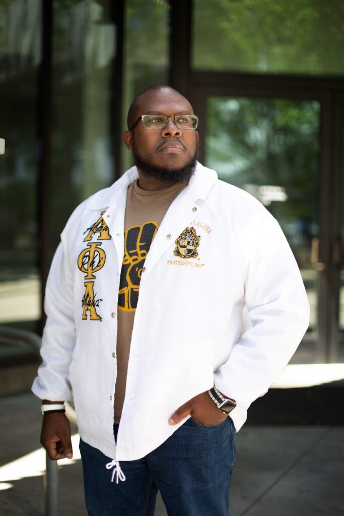 grad photos in alpha phi alpha fraternity jacket