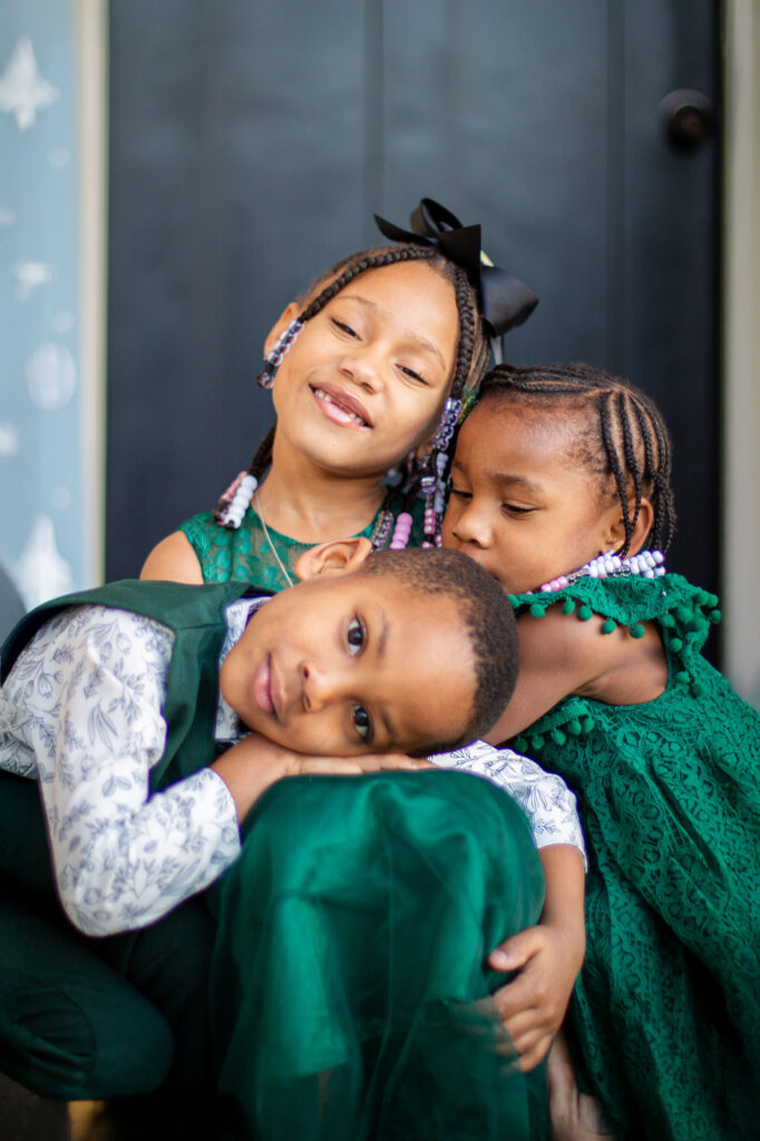 Sibling love captured during a Christmas mini session in Raleigh, NC, featuring a warm and candid family moment.