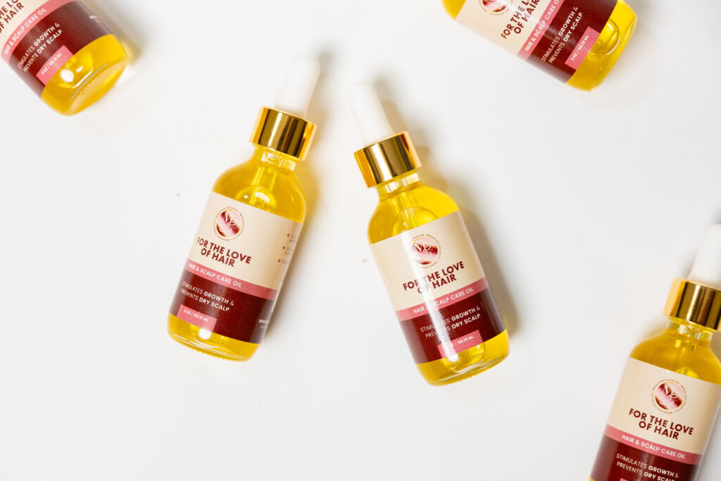 Flatlay of multiple Medallion Styles hair oil bottles featuring vibrant branding and dropper tops.