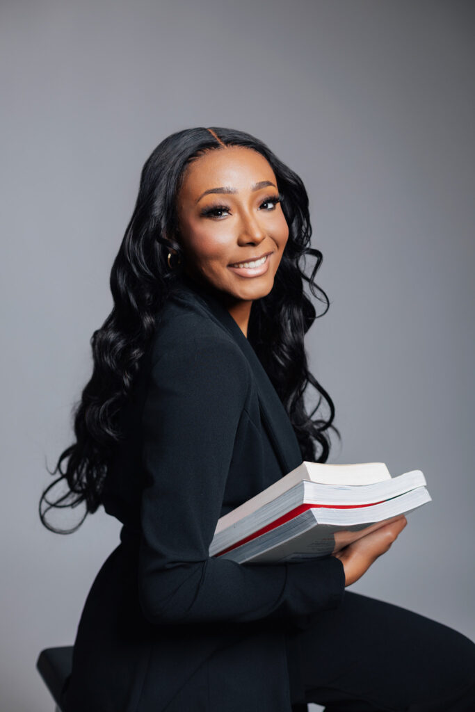 Senior posing with textbooks during grad shoot