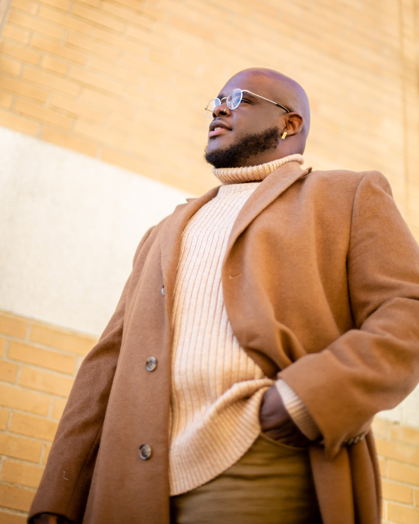 black man standing in confident post wearing tommy hilfiger trench coat