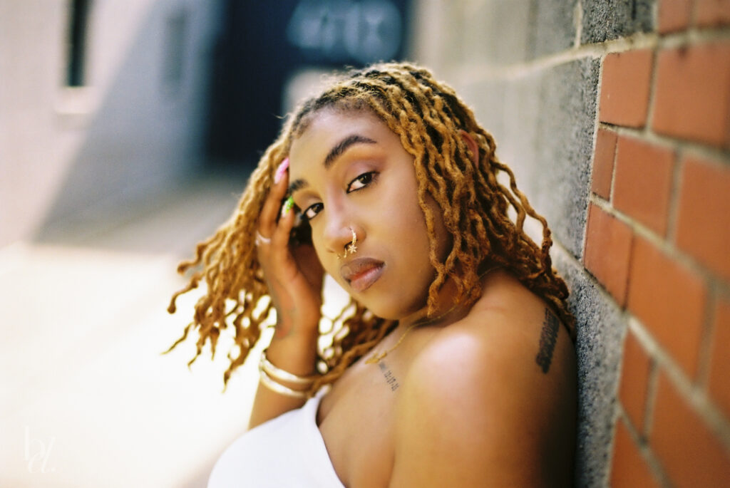 Film image showcasing golden tones and natural light from Kodak Gold 200 on black skin