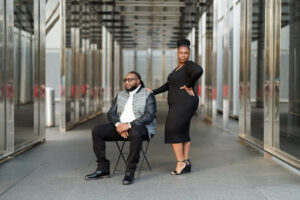 A couple embracing in a modern architectural walkway, posed in an editorial engagement photo with clean lines and soft light