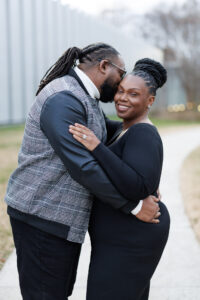A couple walking side by side outdoors, holding each other closely during a relaxed and natural Raleigh engagement session