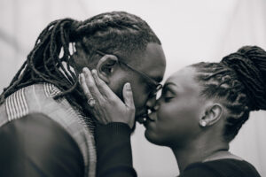 Black and white close up of a couple sharing a kiss, highlighting intimacy and emotion during a Raleigh engagement photo session