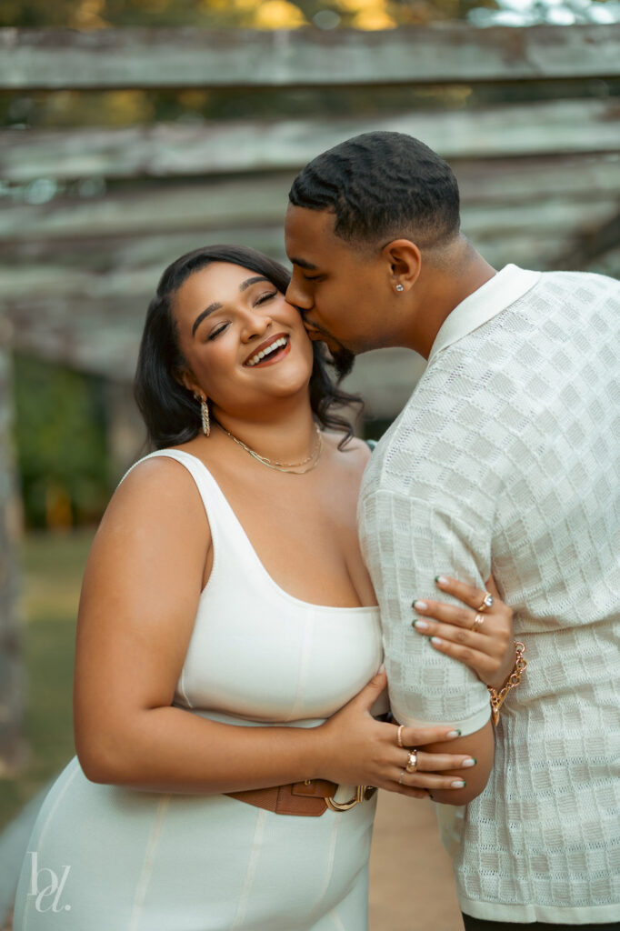 Candid moment of laughter between a couple during their outdoor engagement photos in Raleigh.

