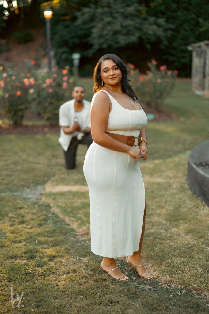Surprise proposal unfolding as one partner kneels behind the other during an engagement session in Raleigh.