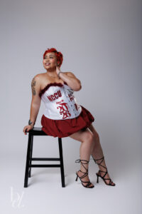 Woman posing in white outfit for NCCU master’s grad photos