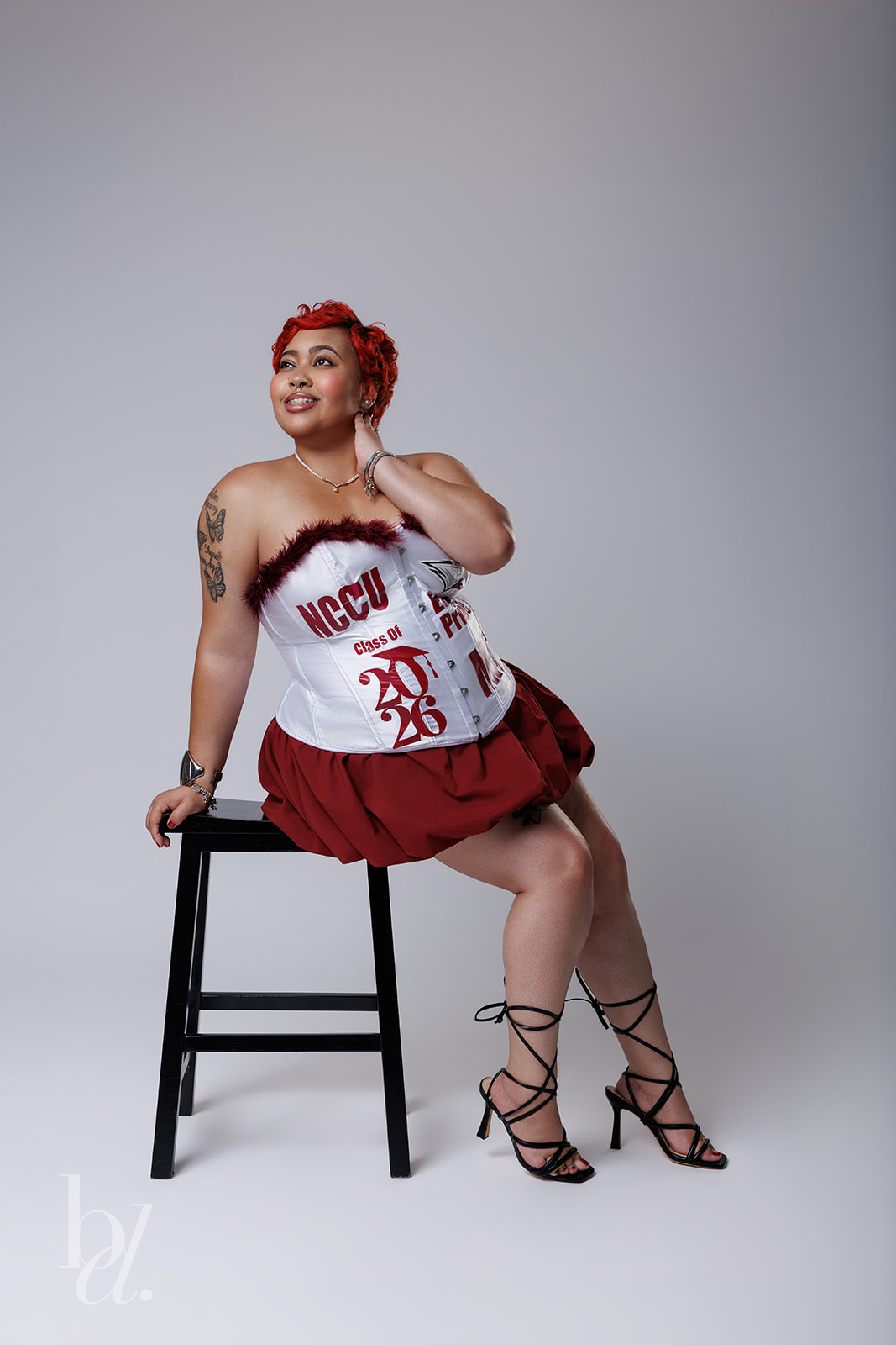 Woman posing in white outfit for NCCU master’s grad photos