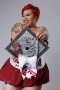 Counseling graduate posing in cap and gown indoors