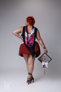 NCCU master’s graduate posing in white dress and hood