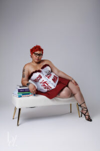 NCCU graduate posing with books in portrait studio