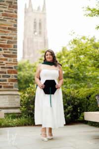 Duke doctoral grad holding cap with Duke Chapel blurred in background