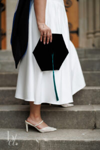 Close-up of doctoral graduate holding graduation cap on Duke Chapel steps