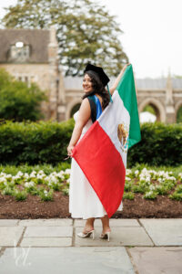 Duke doctoral graduate posing with Mexican flag outside Duke Chapel