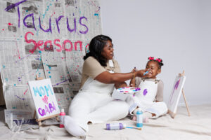 Mother painting her daughter’s face during a playful mommy and me paint themed birthday session