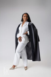 Doctoral graduate wearing white suit and doctoral robe during Raleigh grad session