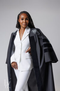 Editorial doctoral graduation portrait with doctoral regalia and white suit