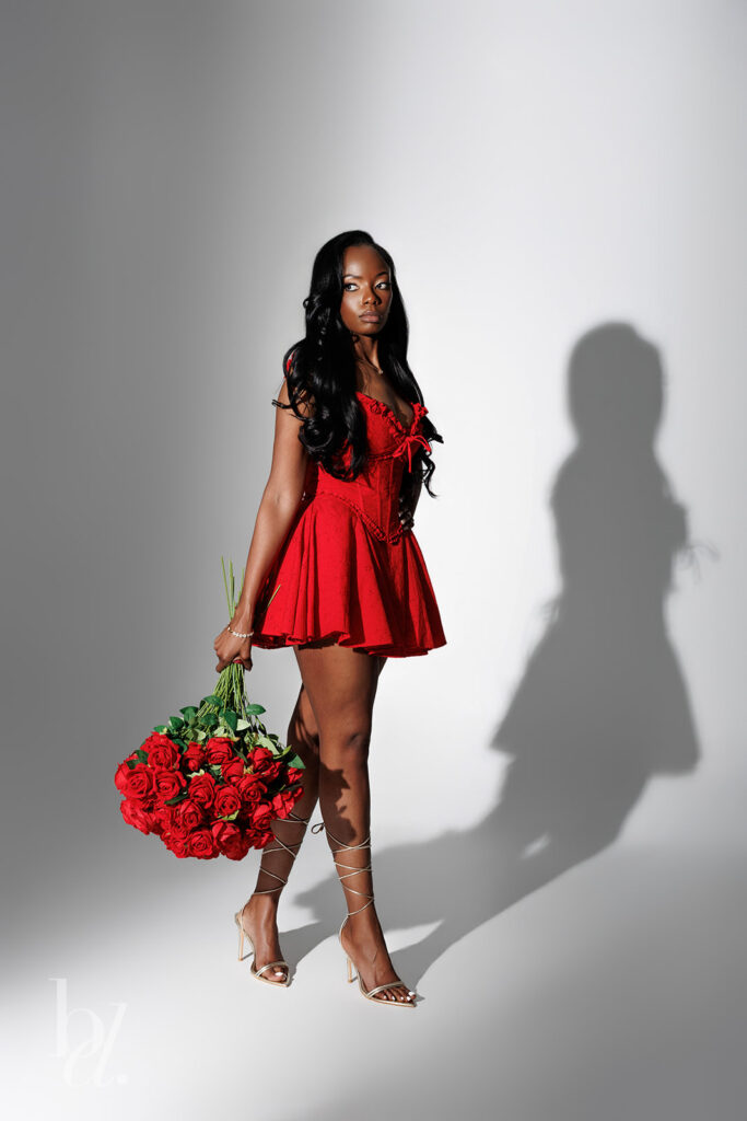 Editorial birthday photoshoot with dramatic shadow lighting and red dress