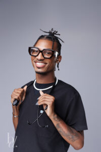 Graduate smiling in black scrubs holding a stethoscope during a Raleigh studio graduation session.